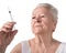 Old woman preparing syringe for making insulin injection