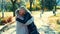 Old woman and pretty young woman hugging each other while walking together in park