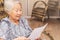 Old woman seated reading carefully a document or terms of a insurance. Old obaasan (grandma), japanese descendant.