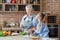 Old woman showing her granddaughter how to cook in kitchen