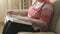 Old woman sitting on the sofa reading a thick book