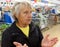 Old woman stands helpless in a supermarket