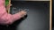 Old woman writing word EDERLY on blackboard