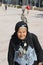 Old women in black clothes with the parrot on the head in the Palm Trees Promenade, Finikoudes beach, Larnaca, Cyprus