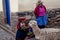 Old Women in traditional dress feeding Alpaca in Pisac, Peru