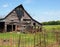 Old wood barn by a rusty fence