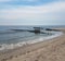 Old wood and cement structure and sand and ocean at beach