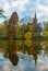 Old wood church reflected in the pond. Tree mirrored in the water on the left