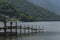 Old wood jetty lake with green mountain at nikko, japan.