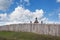 Old wood rustic church building and wooden fence against blue sk