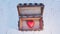 An old wood with rusty metal Chest opened with a very big and chubby red heart inside