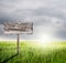 Old Wood sign with slope grass and rainclouds