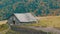 Old wooden abandoned wooden house for cattle in background of picturesque Carpathian mountains in autumn