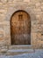 Old wooden arch door with half window.