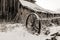 Old wooden barn and farm implement in with winter with snow on t