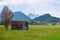 Old wooden barn in a meadow in the Alps in autumn with mountains