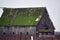 Old wooden barn with a mossy roof in the farm