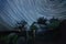 Old wooden barn at night and the starry sky, star tracks