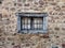 old wooden barred window in a stone house