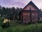 An old wooden Belarusian hut on a farm in the evening, cloudy sky