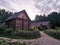 An old wooden Belarusian hut on a farm in the evening, cloudy sky