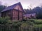 An old wooden Belarusian hut on a farm in the evening, cloudy sky