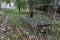 Old wooden bench in the garden. Dead leaves around the bench.