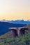 Old wooden bench on hilltop with nice scenic view of the Alps in the evening