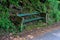 Old wooden bench near trails, road in english Park