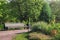 Old wooden bench in a summer garden. Beautiful park in bloom