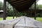 Old wooden bench and a table made of solid round timber in a gazebo, outdoor recreation