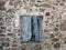 old wooden boarded up window in a stone house