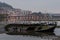 Old Wooden Boat Decaying in the Sand at Eume River Pontedeume in the Background with lighted bridge La CoruÃ±a Galicia