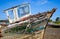 Old wooden boat hull with decayed wood, peeling paint