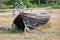 old wooden boat lies on the shore