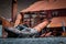 Old wooden boat rests up on shore in front of rusty metal building on Stomness Island-2