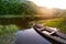 Old wooden boat shore of river surrounded by forest at sunny sum