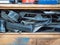 An old wooden box with different devices and motor vehicle parts piled together on its shelves. Close up view on wooden