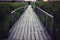 Old wooden bridge over a small shallow river flows into estuary of the Black Sea. Wood bridge leads into the reeds vanishing point