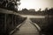 Old wooden bridge to village hill. Vintage gothic rustic black and white photo