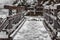 Old wooden bridge in winter in the mountains. Snow-covered bridge over the mountain river