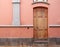 Old wooden brown door in a pink painted spanish house