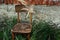 old wooden chair and grass in backyard on background of aged house, calm summer moment, space for text