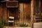 Old wooden chair next to a wooden plank wall with a door and a dovecote