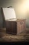 Old wooden chest with open lit on wooden tabletop against grunge