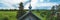 Old wooden church among the overgrown field. rural panoramic landscape. roof of ancient chapel