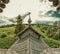 Old wooden church among the overgrown field. rural panoramic landscape. roof of ancient chapel