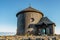 Old wooden church on the top of Snezka,the highest mountain of Czech Republic,Krkonose Mountains. Girl in blue jacket walking to