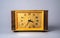 Old wooden clock with with dial in yellow frame and black hands and numbers. Brown vintage watch from USSR with wooden