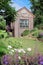 Old Wooden Cottage Style Shed near Flowers in a Country Garden